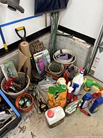 Wide view of gardening items including shovel, spray bottles, bags of soil, plant stakes, gloves, and various planters and pots.