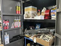Multiple shelves with various cleaning agents including Loctite adhesive products, boxes, tapes, and tools.