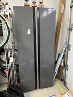 Front view of gray Husky metal cabinet standing upright with two doors and vertical handles.