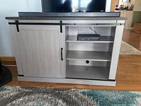 Front view showing sliding barn door closed on left with shelving open on right side.