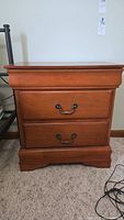 Front view of a wooden nightstand with two drawers closed.