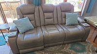 Front view of entire 3-seat sofa with two light blue throw pillows on outer seats