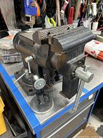 Side angle view showing black cast iron vise with magnetic base and adjustment handle