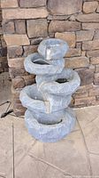 Front view of the gray plastic waterfall fountain showing the entire height and shape with multiple cascading bowls.