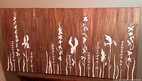 Full view of rectangular canvas artwork with floral silhouettes in white on a warm brown and copper textured background.