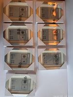 Photo showing ten silver-colored IKEA octagonal photo frames stacked in two columns. Each frame is unopened with white cardboard corners protecting edges.