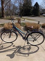 Left-side view of full bicycle showing step-through frame, saddle, rack and wheels