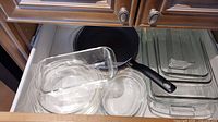Glass and rectangular baking dishes on a kitchen drawer.