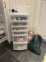 Overall shot of the plastic storage drawer bin with some bags beside it showing the entire lot