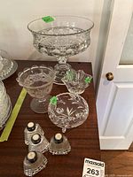 Overview of the lot showing four bowls and two salt and pepper shakers on a wooden surface.