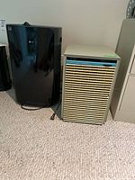 Two dehumidifiers side by side: modern black LG PuriCare and vintage beige Electro-Home.