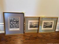 Photo showing three framed artworks: one print featuring musicians and two landscape prints.