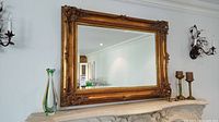 Full front view of the mirror mounted above mantel, showing overall frame and glass reflectivity