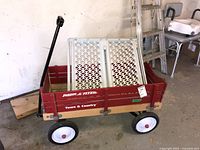 Photo of Radio Flyer Town & Country wagon with red wooden slats and black wheels inside garage.