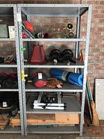 Front view of metal shelving unit showing all five shelves with various unrelated items stored on them.