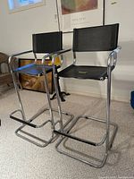 Two chrome cantilever bar stools positioned side by side