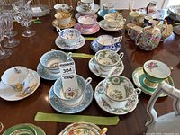 Photo showing 6 teacups and saucers with various floral patterns and colors, including Wedgwood, Foley, and Roslyn brands.