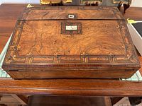 Closed portable writing box showing wood marquetry and mother-of-pearl inlay on lid