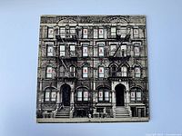 Front cover photo of vintage Led Zeppelin Physical Graffiti album with characteristic building image and red letter windows spelling 'Physical Graffiti'