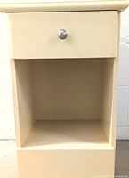 Front view of the night stand showing the drawer and open cubby.