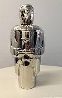 Front view of the butler-shaped stainless steel cocktail shaker showing detailed front with tray and martini glass design.