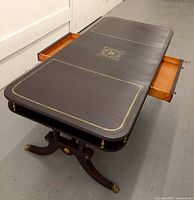 Top view of dark brown coffee table with gold detailing on the surface and drawers pulled out