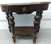 Full view of the vintage wooden side table with decorative legs and lower shelf.
