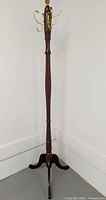 Full view of the tall wooden coat rack showing the turned wood post and tripod base.