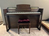 Front view of antique Eavestaff Pianette upright piano in dark brown wood with bench in front, showing overall size and condition.