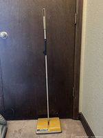 Full view of Hoky 24S commercial manual vacuum showing the yellow body and metal handle