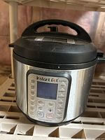 Front view of stainless steel Instant Pot Duo Plus with digital control panel and buttons