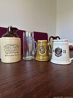 Set of 3 university handled cups and 1 jug arranged on dark wood surface