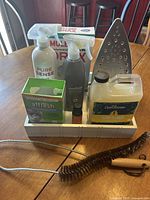 Full lot shot showing all items including bottles, boxes, iron, organizer tray, and lint trap cleaner.