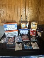 Overview of all lightbulbs in a variety of types including boxed multi-packs and loose bulbs, showing brands such as Sylvania, GE Relax, and ACD, plus several smaller appliance bulbs.
