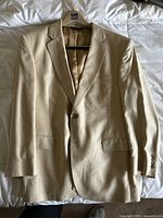 Beige silk blazer laid flat showing style and condition.