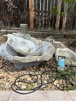 Multiple cast stone fountain bowls stacked with pump and tubing visible