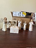 Photo of 6 angel figurines and one rectangular box with angel star design, including wire winged angels and praying angels