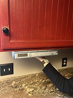 Under cabinet silver Sony radio CD player affixed beneath kitchen cabinet, showing front and installed position.