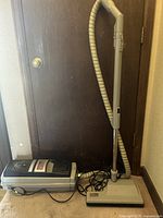 Wide image of the Electro Lux Ultra Lux 2000 vacuum cleaner showing the main body, attached hose, and metal wand standing upright.