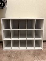 Front view of white shoe organizer, showing 15 square compartments in a 3x5 grid