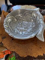 Top-down view of the cast metal serving bowl showing dolphins and detailed ocean scene.