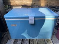 Front view of vintage blue Coleman cooler with visible logo and latch