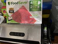 FoodSaver vacuum sealing system unit with original box showing packaging details for 4 heat-seal rolls and 2 heat-seal rolls
