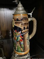 Side view showing a soldier aiming a weapon in front of a stone tower on the stein