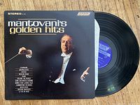 Photo of Mantovani's Golden Hits vinyl record album cover and record itself showing good condition and legible text.