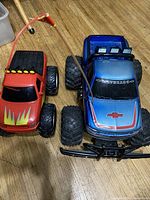 Top view of red and blue toy remote control cars showing front and side details, tires, and body design.