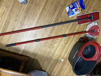 Pair of Vileda mops with long metal handles, mop bucket, and boxed extra mop head on wooden floor.