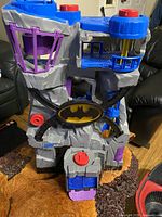Front view of the Batman Batcave playset showing its overall structure, colors, and Batman logo on the front.