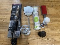 Overview of all items showing Revlon hair curler, hand mirror, cotton rounds, metal Buddha head figurine, vintage brush, and barber pole bottle.