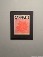 Front view of the framed limited edition screen print featuring a red maple leaf and the word CANNABIS.